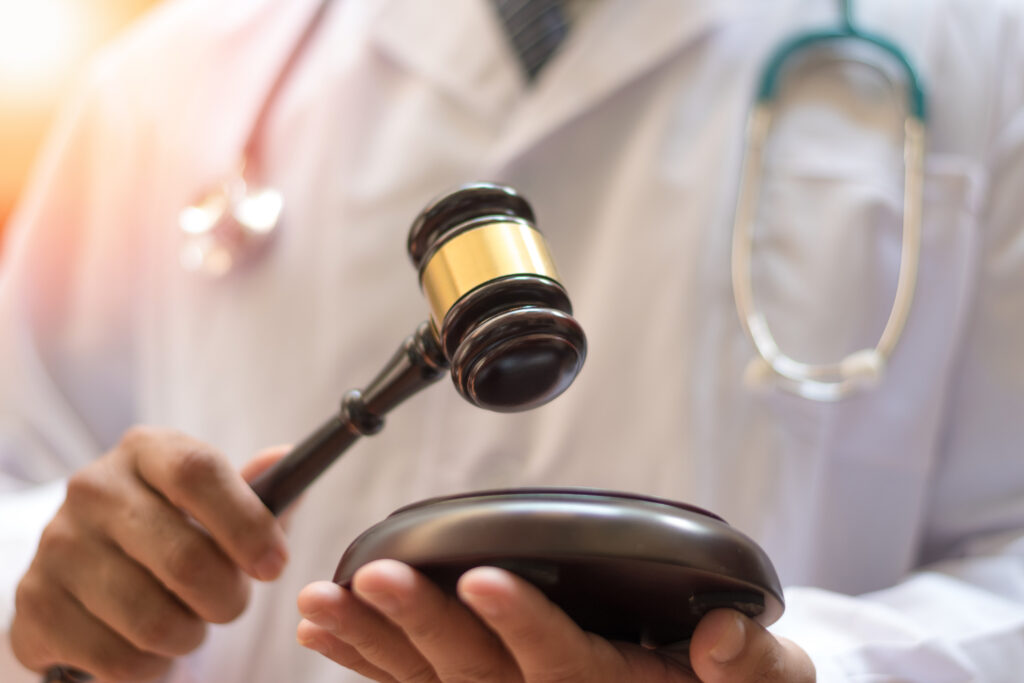 Primo piano di un martelleto in mano a un medico legale